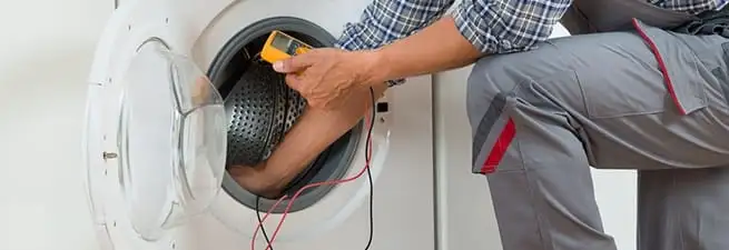 Dryer repair technician inspecting and repairing a clothes dryer in Chandler, AZ