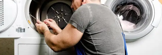 Dryer repair technician fixing a clothes dryer drum in Chandler, AZ