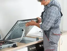 Appliance repair technician installing a built-in cooktop in Chandler, AZ