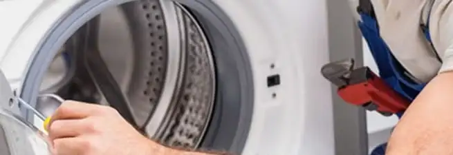 Appliance technician repairing a clothes dryer drum and internal parts in Chandler, AZ