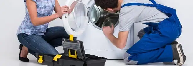 Washer repair technician inspecting a front-load washing machine with tools in Chandler, AZ