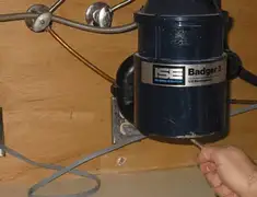 Garbage disposal repair technician tightening the mounting ring under a sink in Chandler, AZ