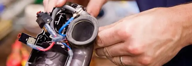 Vacuum repair technician reconnecting wiring and components in Chandler, AZ
