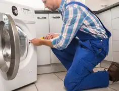Washing machine repair technician servicing a front-load washer in Chandler, AZ