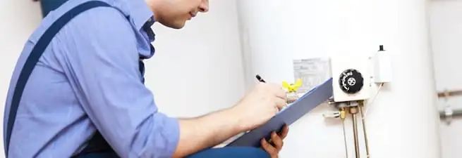 Water heater repair technician inspecting the unit and recording service notes in Chandler, AZ
