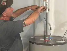 Water heater repair technician tightening supply line connections in Chandler, AZ
