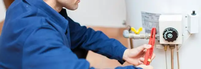 Water heater repair technician adjusting the temperature control and gas valve in Chandler, AZ